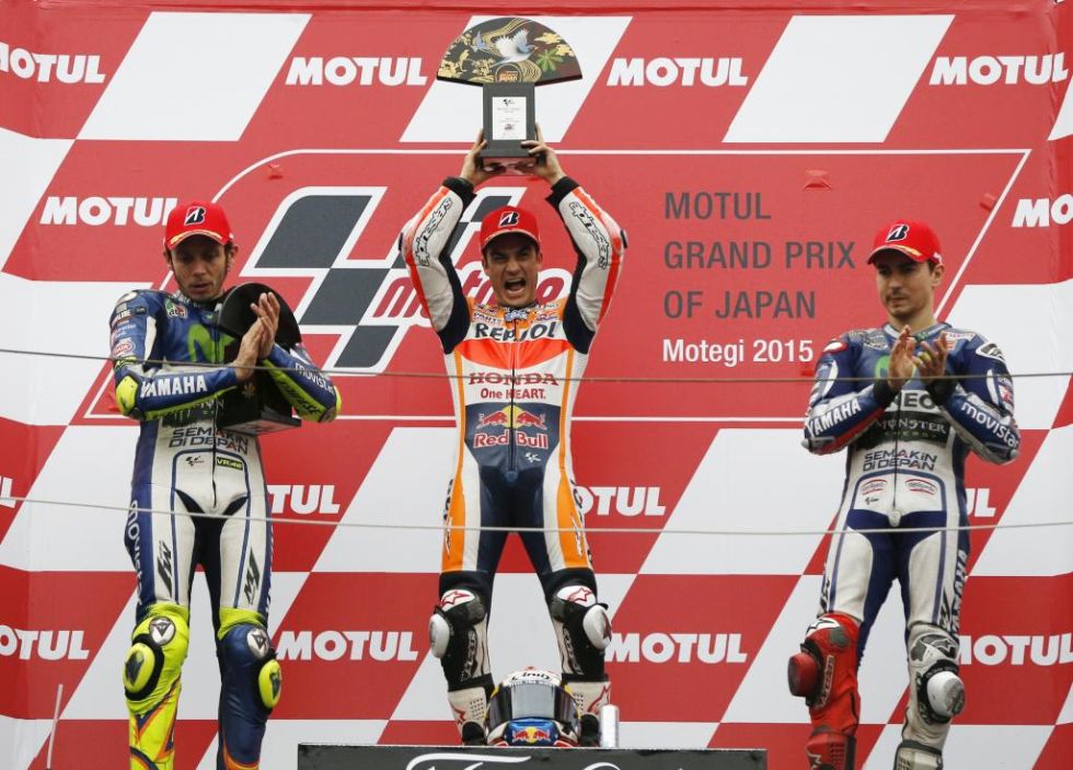 Pedrosa celebra su triunfo en el podio de Motegi con Rossi y Lorenzo a ambos lados.