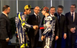 Valentino Rossi y Jorge Lorenzo se saludan en el acto oficial, delante...