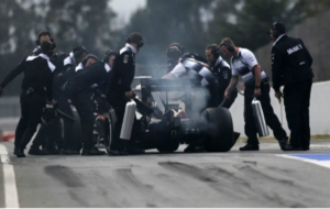 Mecnicos de McLaren Honda asisten a Button en el pit lane de...