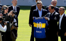 Hollande aprecia la camiseta de Boca que acaba de obsequiarle Macri.