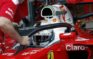 Un mecnico instala el 'halo' en el Ferrari de Vettel.