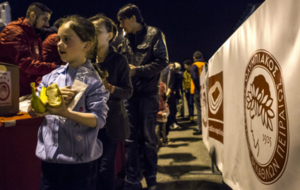 Los refugiados sirios recogen la comida entregada por el club.