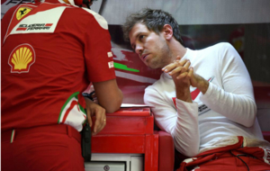 Sebastian Vettel charla con su ingeniero en su box del GP Bahrin...