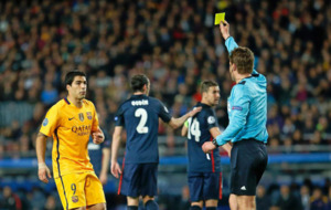 Felix Brych le enseña una tarjeta amarilla a Luis Suárez durante el...