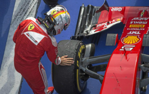 Vettel comprueba el estado de sus neumticos en la llegada al podio...