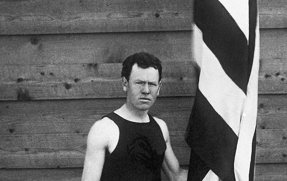 James B. Connolly posando co la bandera de EE.UU.