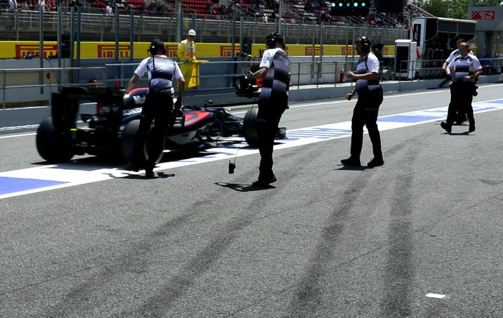 Mecnicos de McLaren Honda empujan a Fernando Alonso en el pit lane...