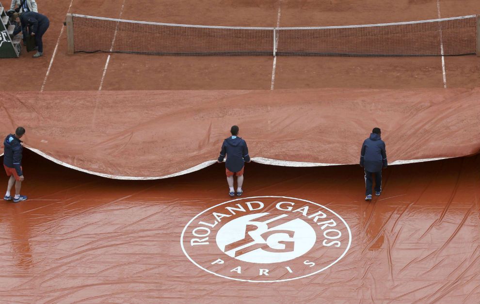 Los operarios cubren la pista central de Roland Garros.