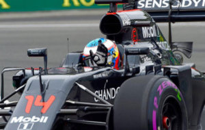 Alonso saluda con la mano desde su McLaren.