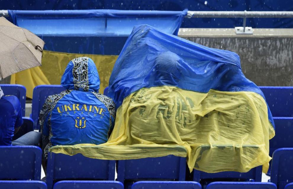 Ukraine supporter protect themselves from the rain during the Euro...