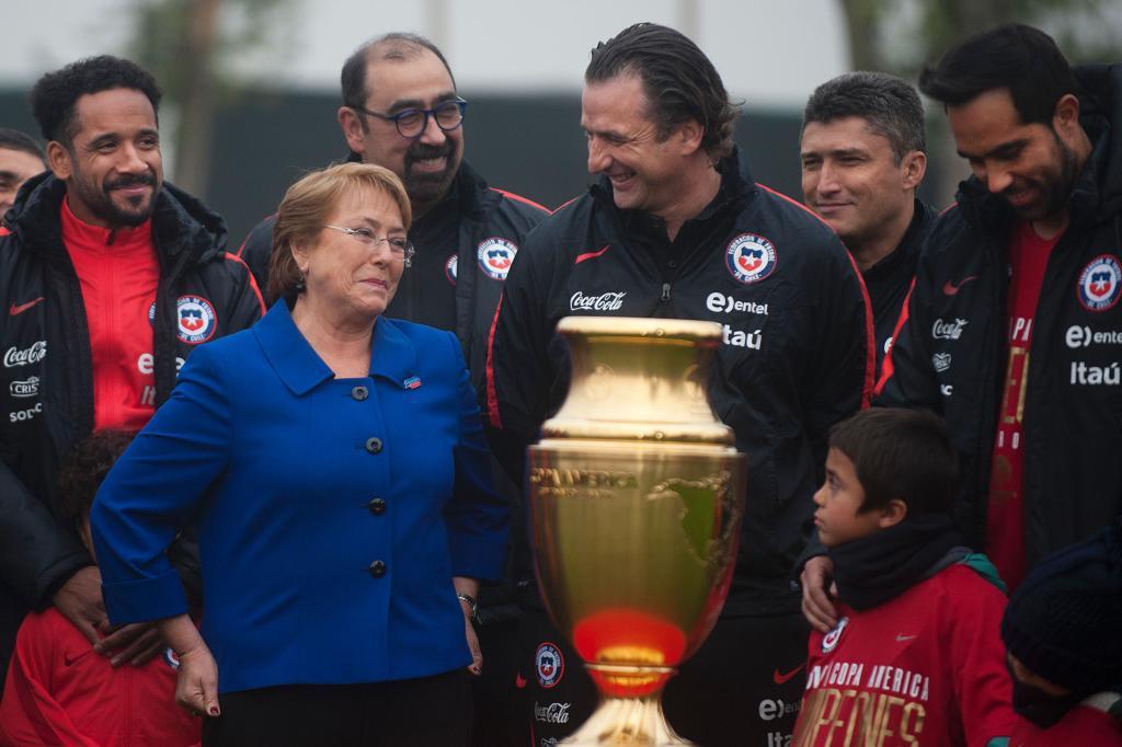 Michelle Bachelet, presidenta de Chile, junto a Pizzi y el trofeo.