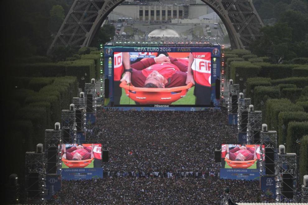 Fans watch from the Eiffel Tower fanzone as Ronaldo is stretchered out...