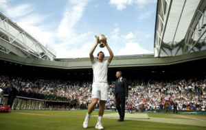 Andy Murray muestra su trofeo sobre la pista de Wimbledon