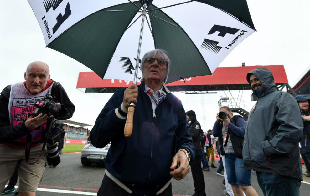 Bernie Ecclestone se protege de la lluvia en el Gran premio de...