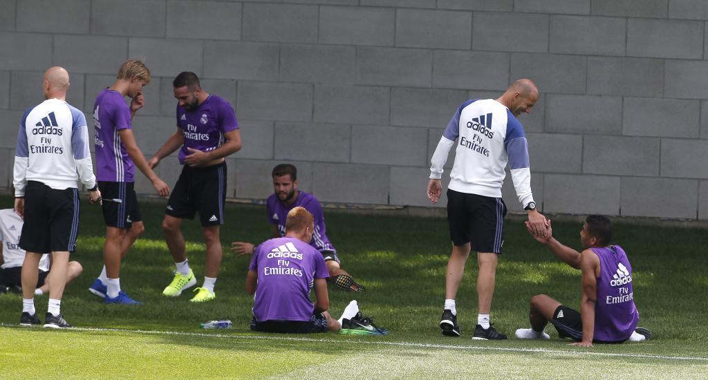 Zidane felicita a sus jugadores durante el entrenamiento de ayer