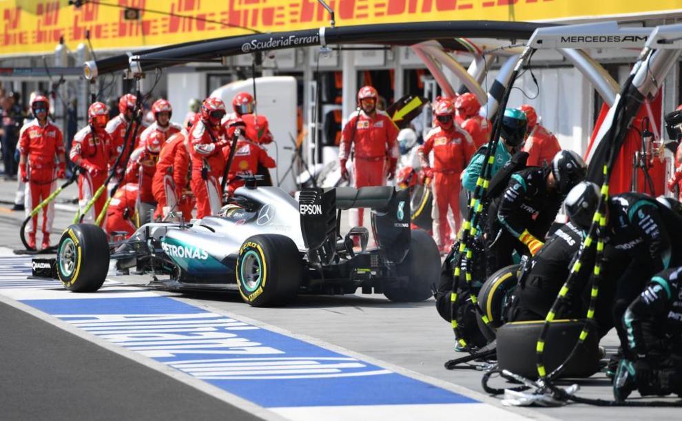 Mecnicos del equipo Mercedes tras el cambio de ruedas de Lewis...