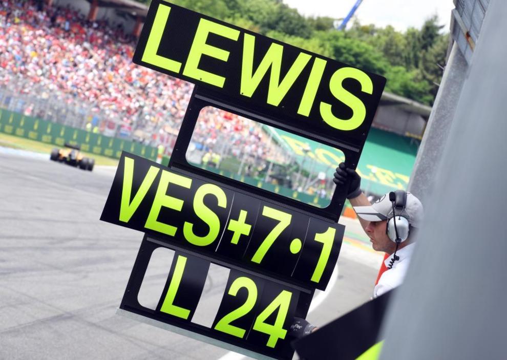Un miembro del equipo Mercedes mostrando la tablilla a Hamilton