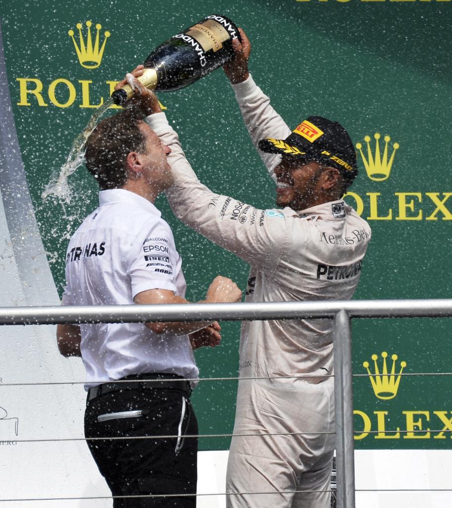 Lewis Hamilton celebrando la victoria con un miembro del equipo...