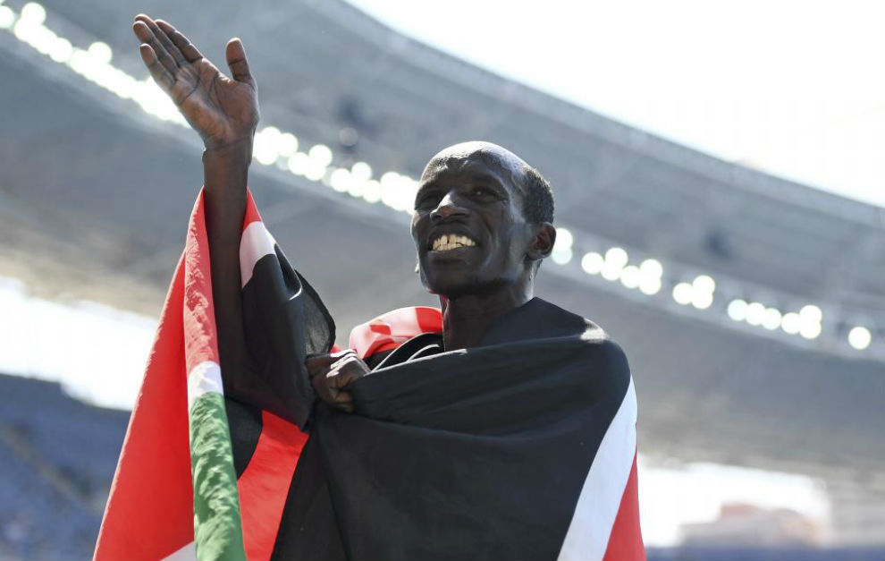Kemboi celebra el bronce envuelto en la bandera de  pas.