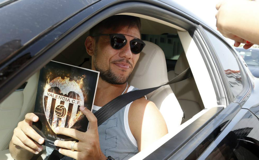 Alves coge una revista con el escudo del Valencia al salir de Paterna.