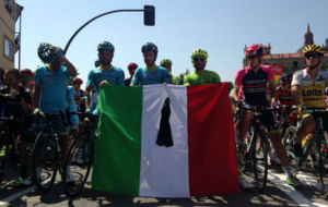 Algunos de los ciclistas italianos, sosteniendo la bandera de su pas...