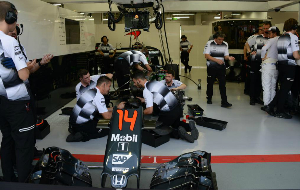 Los mecánicos de McLaren Honda, en el box del equipo durante el...