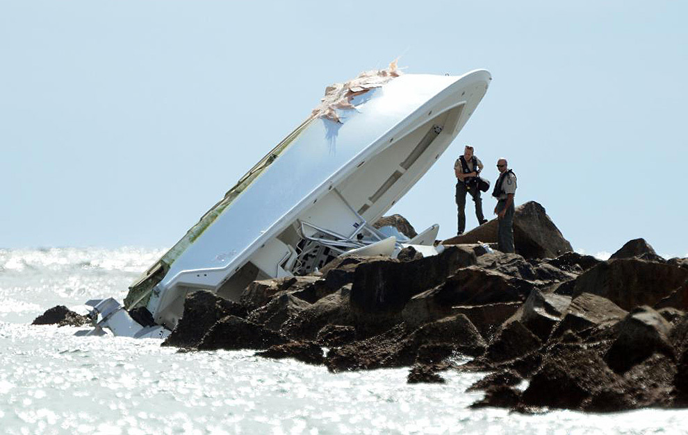 Investigators look over the overturned boat.