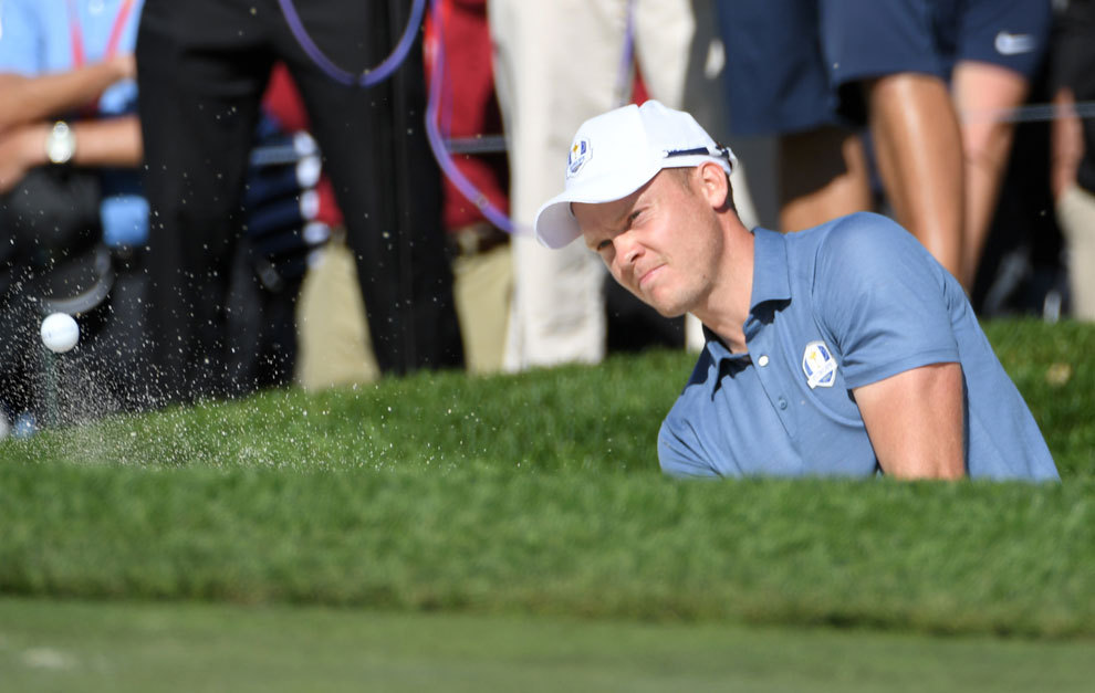 Danny Willett plays a shot from the bunker on the fourth hole.