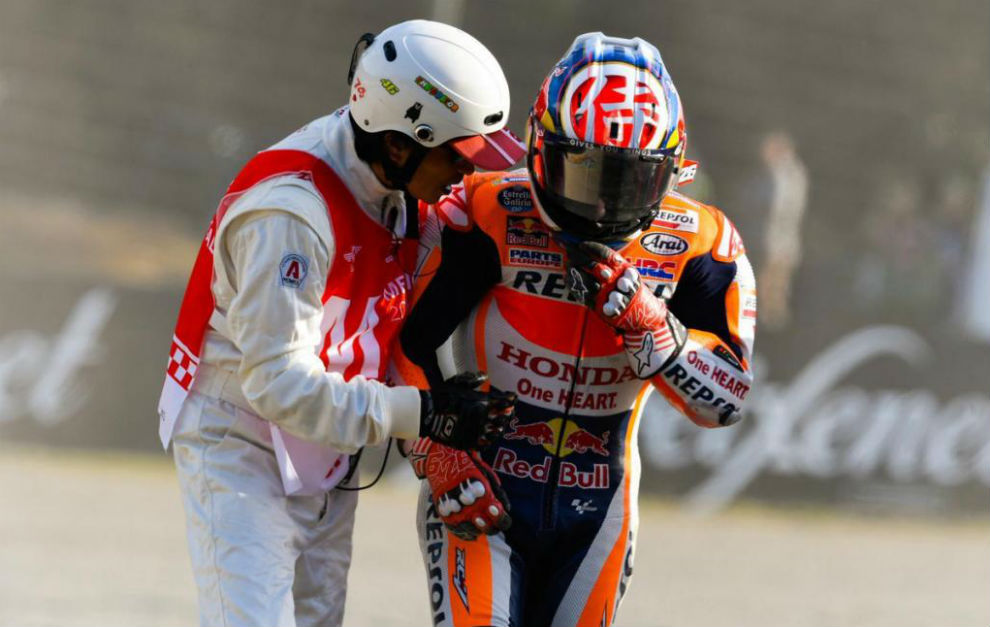 Un comisario socorre a Pedrosa tras su cada en el GP de Japn.