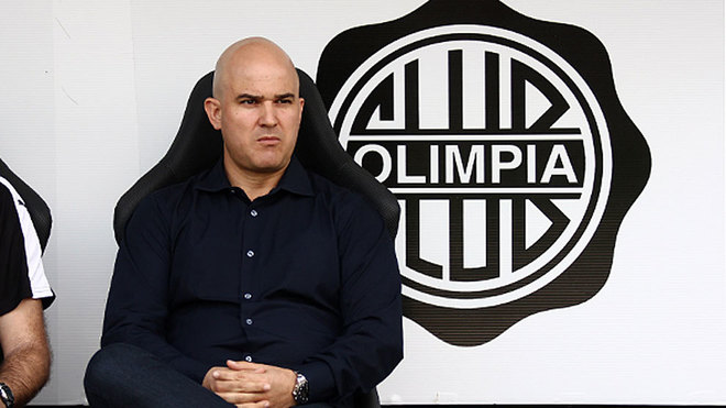Fernando Jubero posa con el escudo de Olimpia de Asuncin detrs...