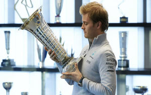 Rosberg mirando la firma de su padre en el trofeo de campeones
