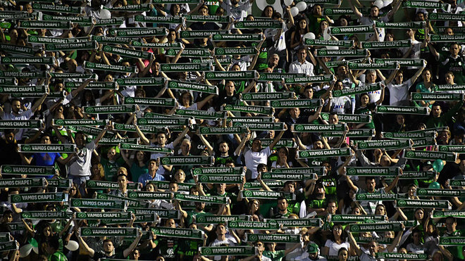 Aficionados del Chapecoense muestran bufandas verdes.
