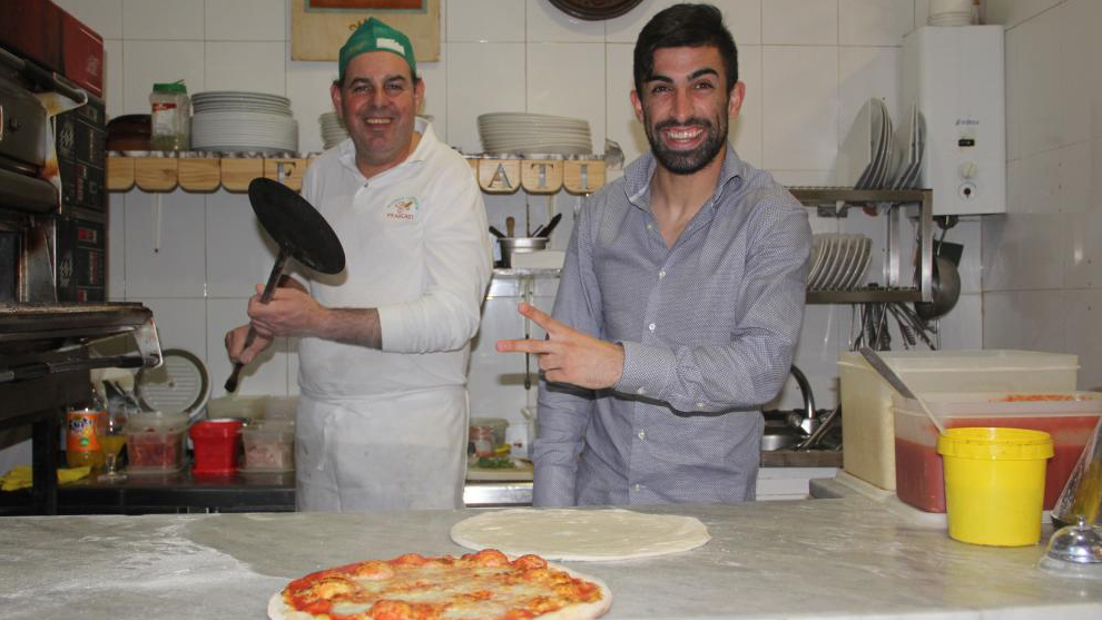 Майкл Сантос позирует на кухне во время приготовления пиццы