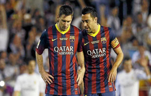 Messi y Xavi hablan durante un partido.