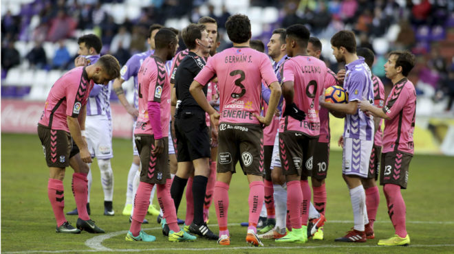 Los jugadores de Valladolid y Tenerife rodean al rbitro.