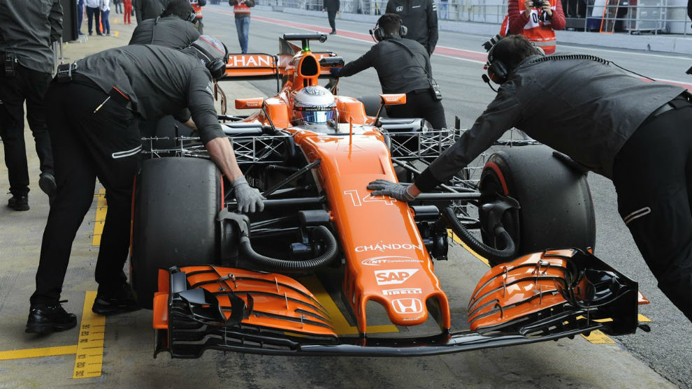 Los mecnicos empujan el McLaren.