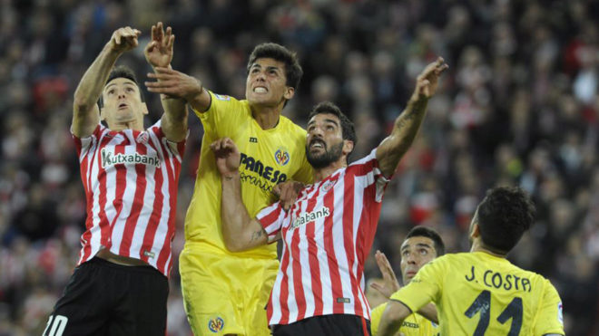Raúl García y Aduriz saltan durante un partido contra el Villarreal...
