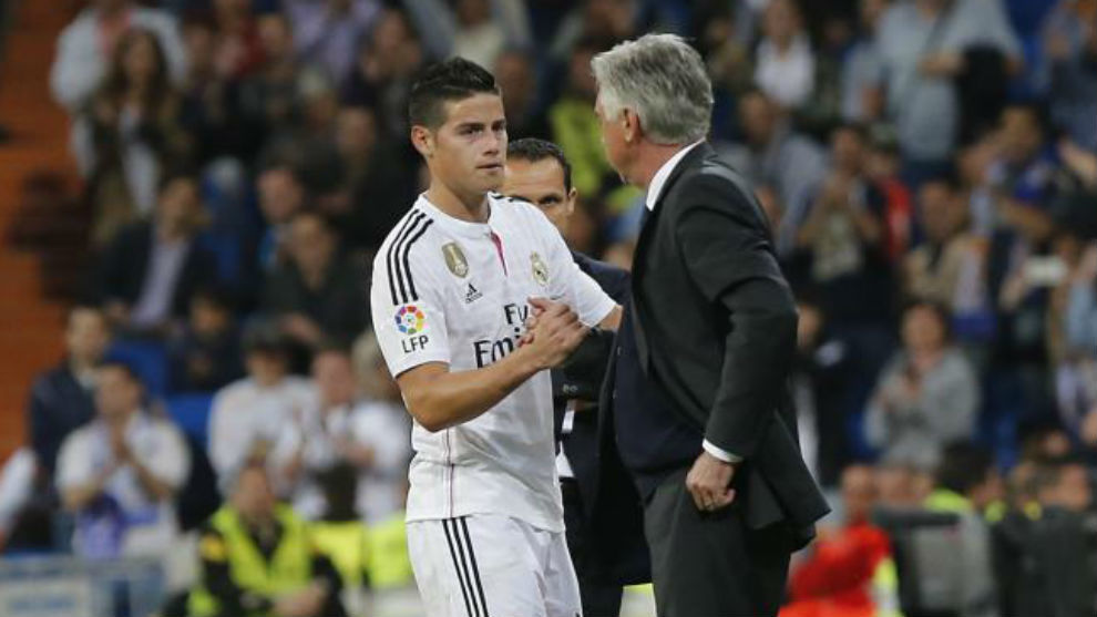 James le da la mano a Ancelotti en un partido del Real Madrid