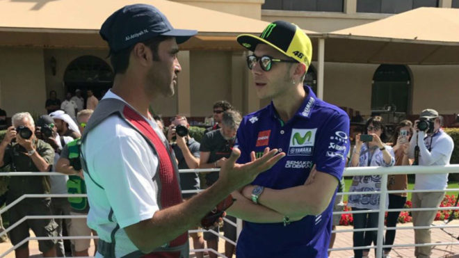 Nasser Al Attiyah y Valentino Rossi charlan antes del GP de Qatar.