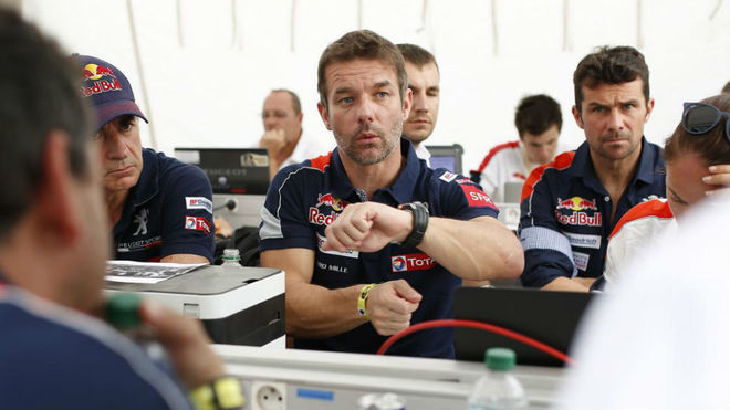 Loeb comenta algn detalle del Peugeot 3008 DKR en presencia de...