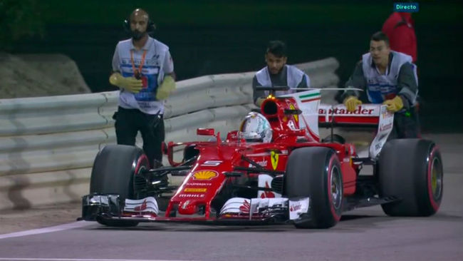 Los comisarios del circuito empujan en Ferrari de Vettel hasta el...