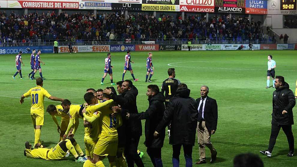 Los jugadores del Huesca se lamentan al fondo mientras los del Cdiz...