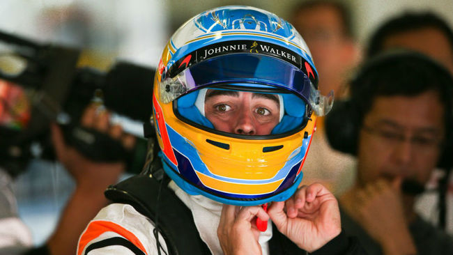 Fernando Alonso se coloca el casco de F1.
