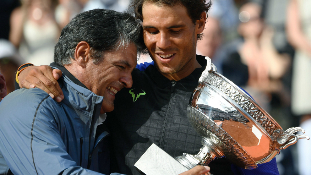 Toni Nadal entrega el trofeo de Roland Garros a su sobrino Rafa.