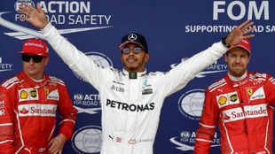 Hamilton celebra la 'pole' en presencia de Kimi y Vettel.