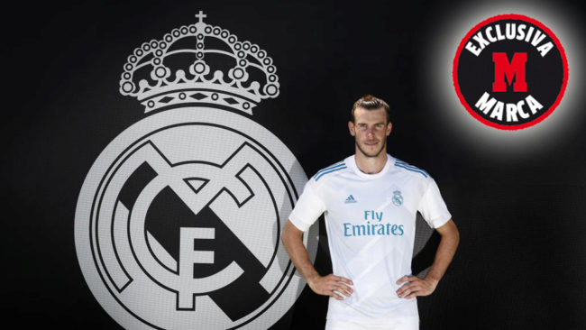 Gareth Bale posando con la camiseta y el escudo del Real Madrid.