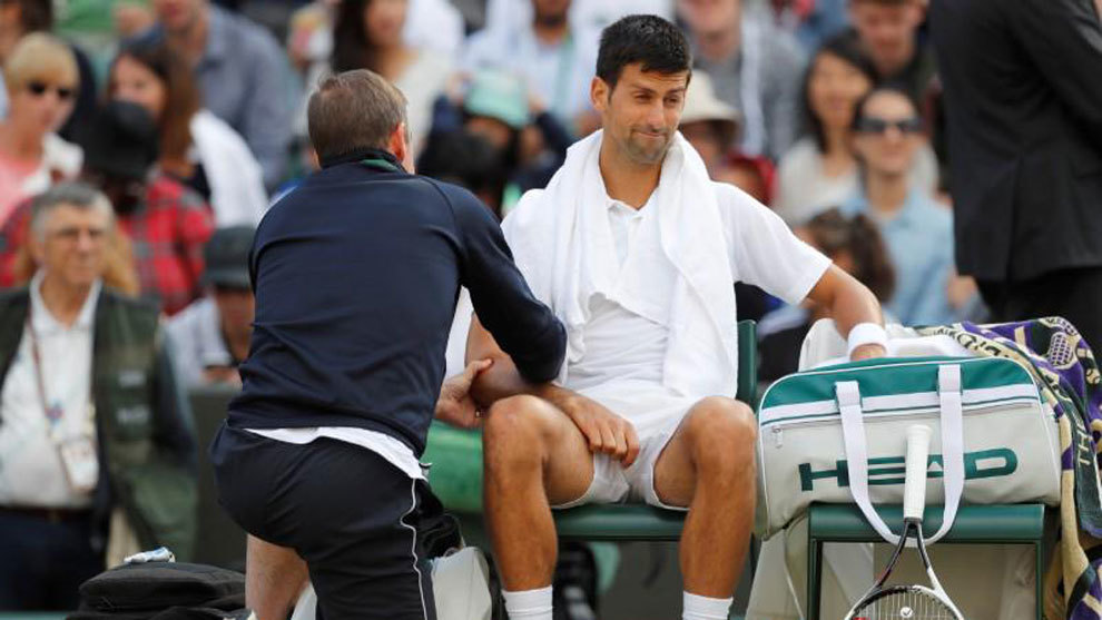 Novak Djokovic recibiendo un masaje en su codo lesionado en Wimbledon.