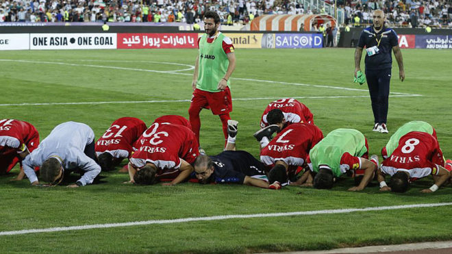 Syria&apos;s players pray at the end of the match against Iran