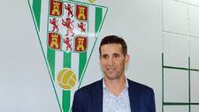 Juan Merino posa delante del escudo de su nuevo club en El Arcngel