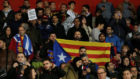 Aficionados sostienen la bandera de Catalua mientras otro muestra...